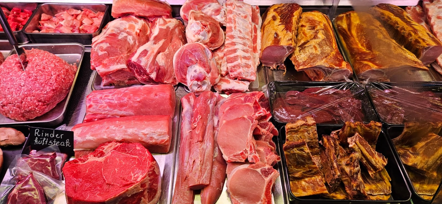 Hecht – Fleischerei – Das Bild zeigt verschiedene frische Fleischprodukte, vermutlich aus einer Metzgerei oder einer Feinkosttheke.